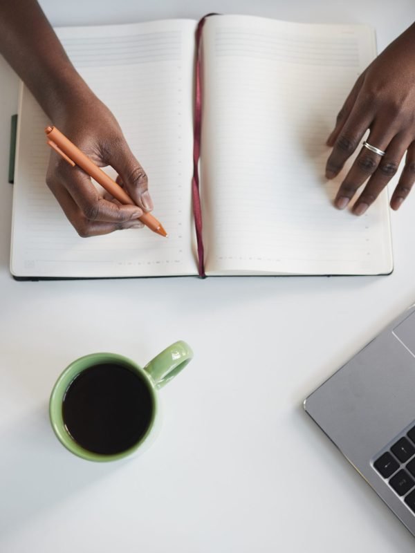 Minimal,Top,View,Of,Unrecognizable,African-american,Woman,Writing,In,Planner